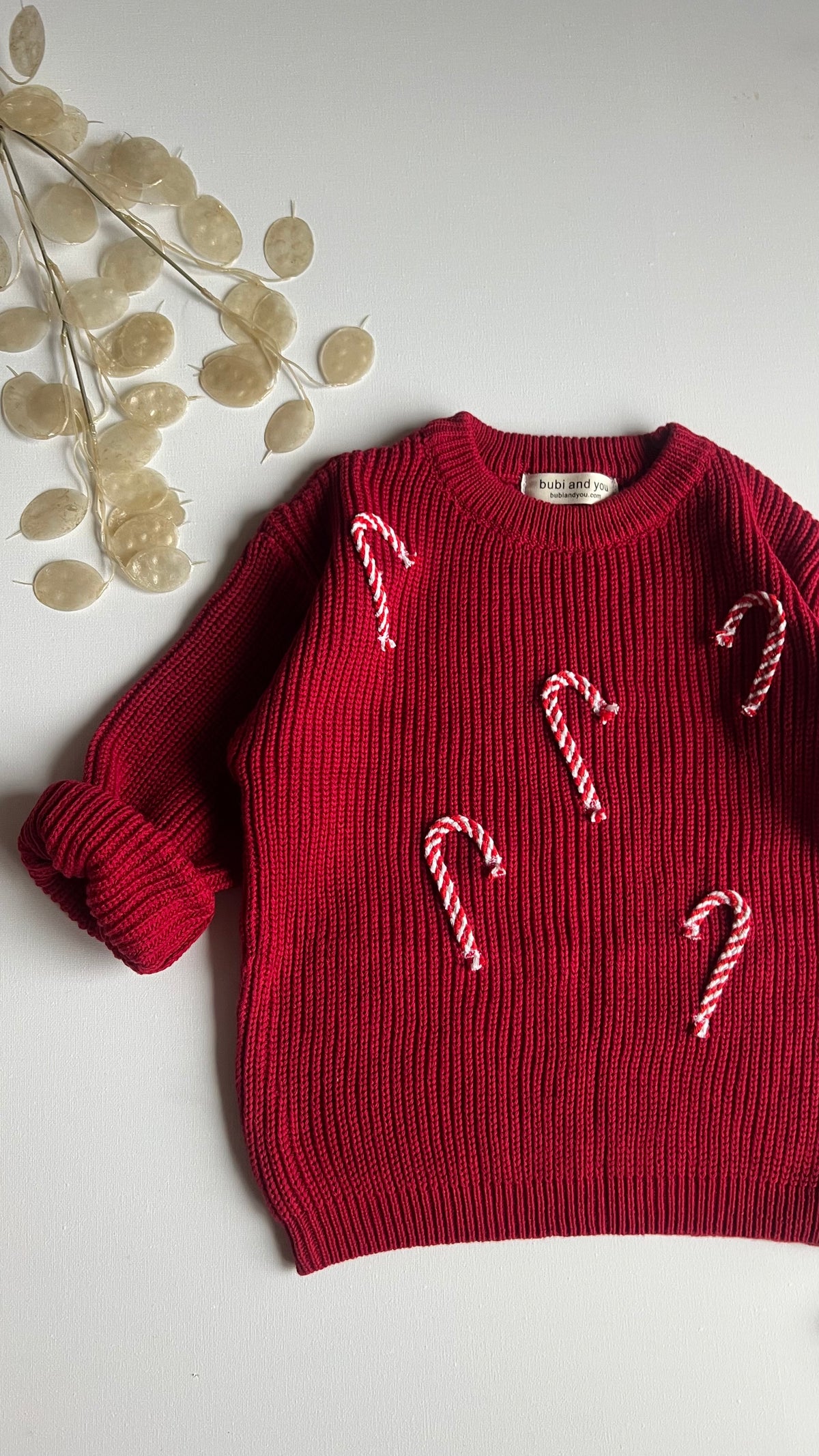 Roter Strickpullover mit Zuckerstangen-Applikationen als Weihnachtsoutfit