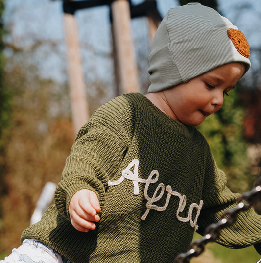 Personalisierter Strickpullover mit Namen in Waldgrün – getragen von Kind