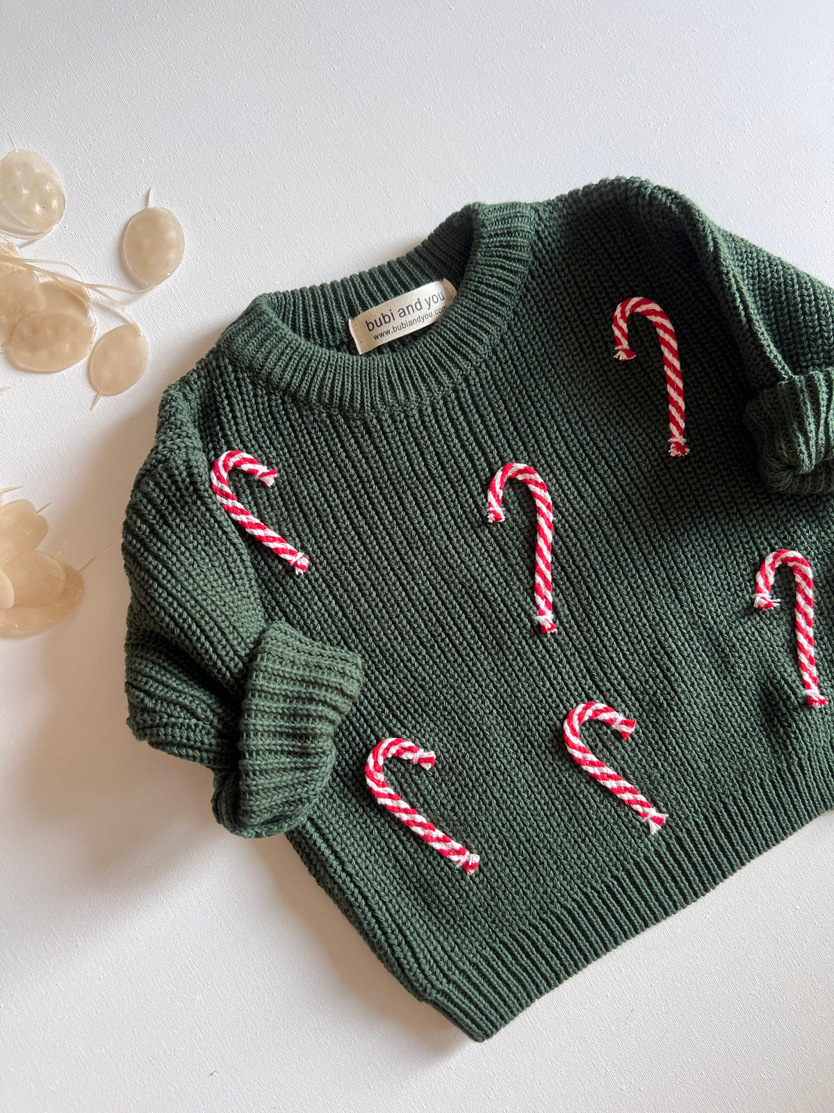 Smaragdgrüner Strickpullover mit roten Zuckerstangen-Applikationen als Weihnachtsoutfit